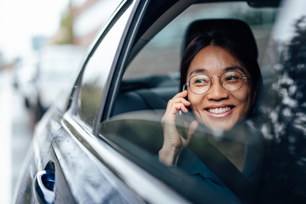 smiling-asian-woman-in-the-car-having-a-phone-call-2023-11-27-05-00-15-utc